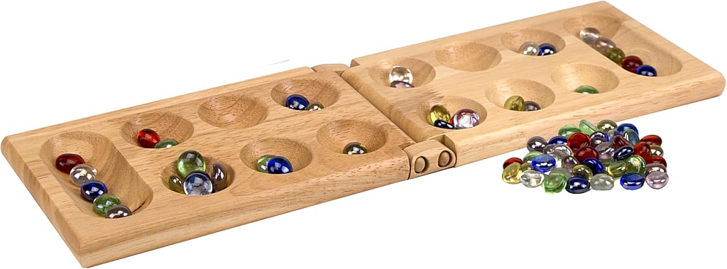wooden mancala game board and colorful marbles or stones with a white background