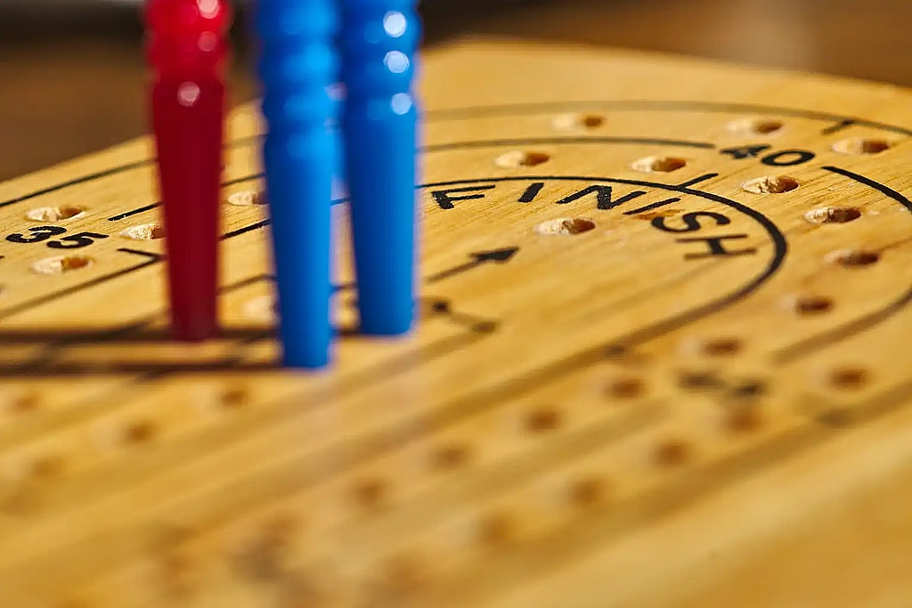 Close up of a cribbage board and pegs, cribbage, pegs, board game, card game, blue pegs, red pegs