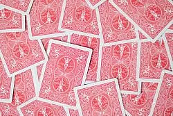 Red playing cards scattered creating an intricate and ornate pattern for gaming or decor.