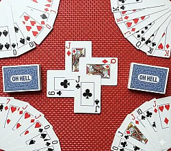 An overhead illustration of a hand of cards for the Oh Hell card game, spread out on a wooden table. The focus is on the cards, which are arranged in a fan-like manner and show various suits and ranks. A player's hand is visible at the bottom, holding some of the cards.
