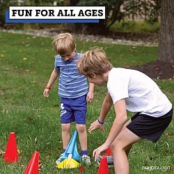two young boys playing capture the flag outdoors on grass field.