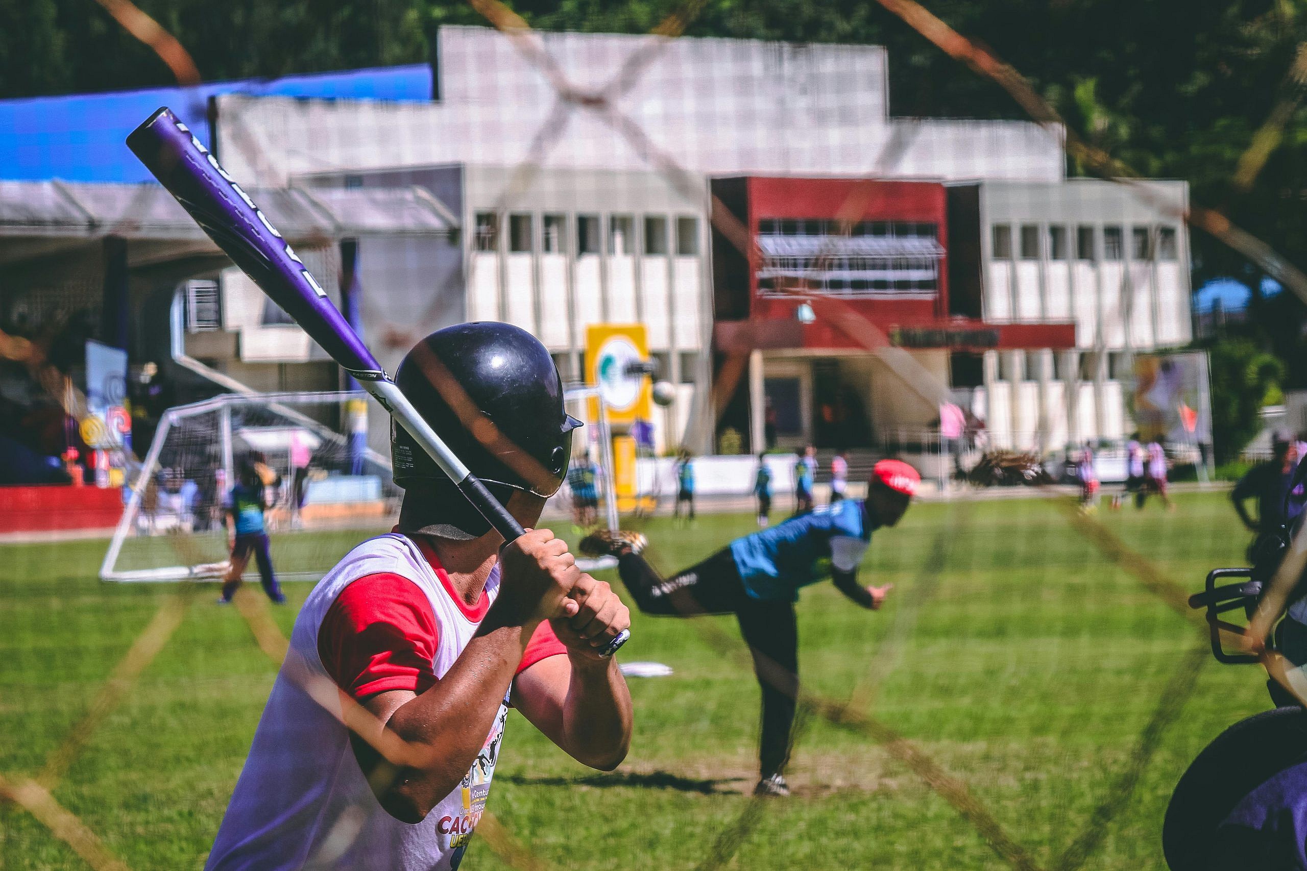 Action shot of a youth baseball game with focus on the batter and pitcher.