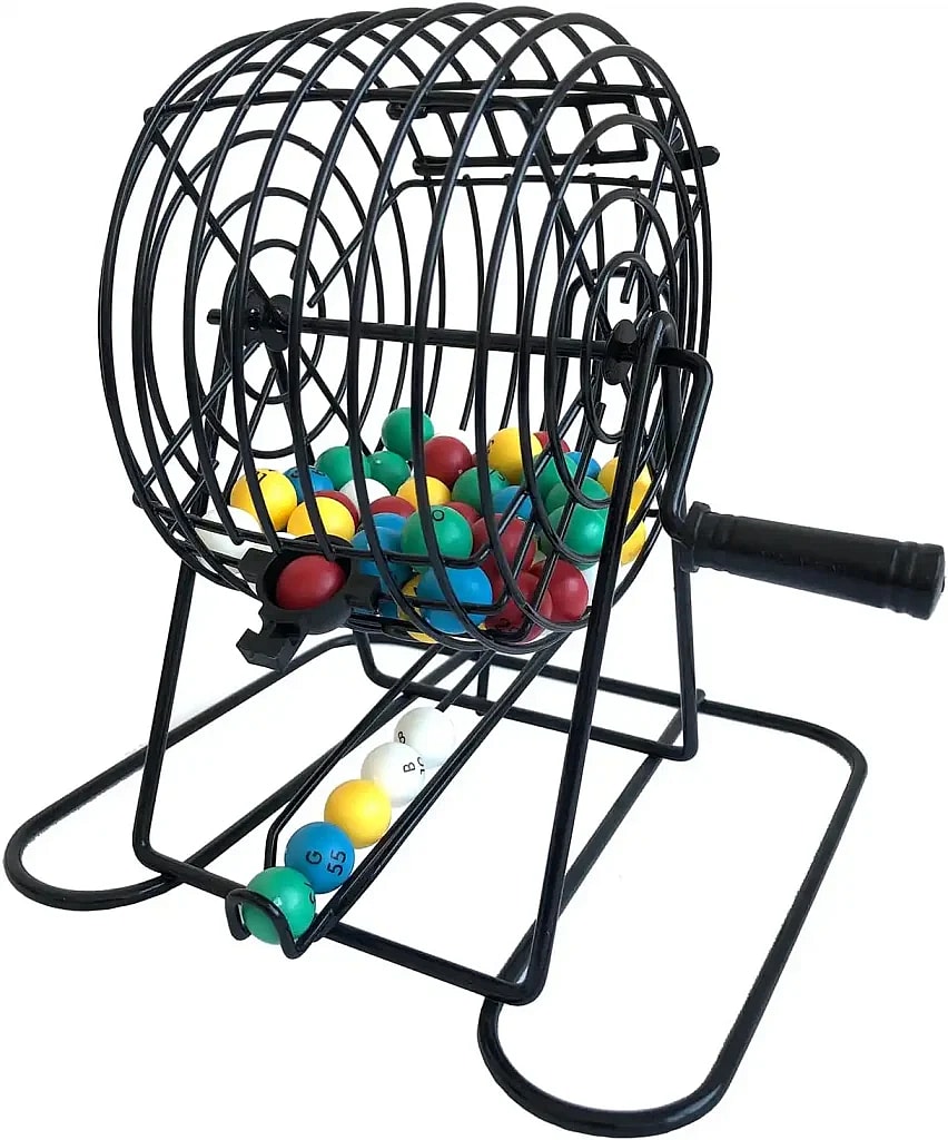 A small, black wire bingo cage or lottery cage used for randomly drawing numbered balls. The cage is full of multi-colored balls, and a few white, yellow, and green balls are resting in the tray below the cage.